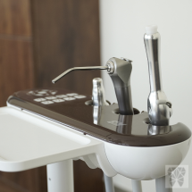 A dental chair with a sink and dental equipment in a neat and hygienic clinical environment.