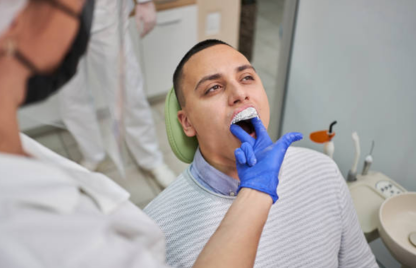 A man is reclining and getting crown treatment during a dental appointment with an expert dentist.