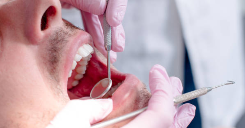 A man getting tooth Extraction And Removal Treatment by Expert dentist using dental tools.